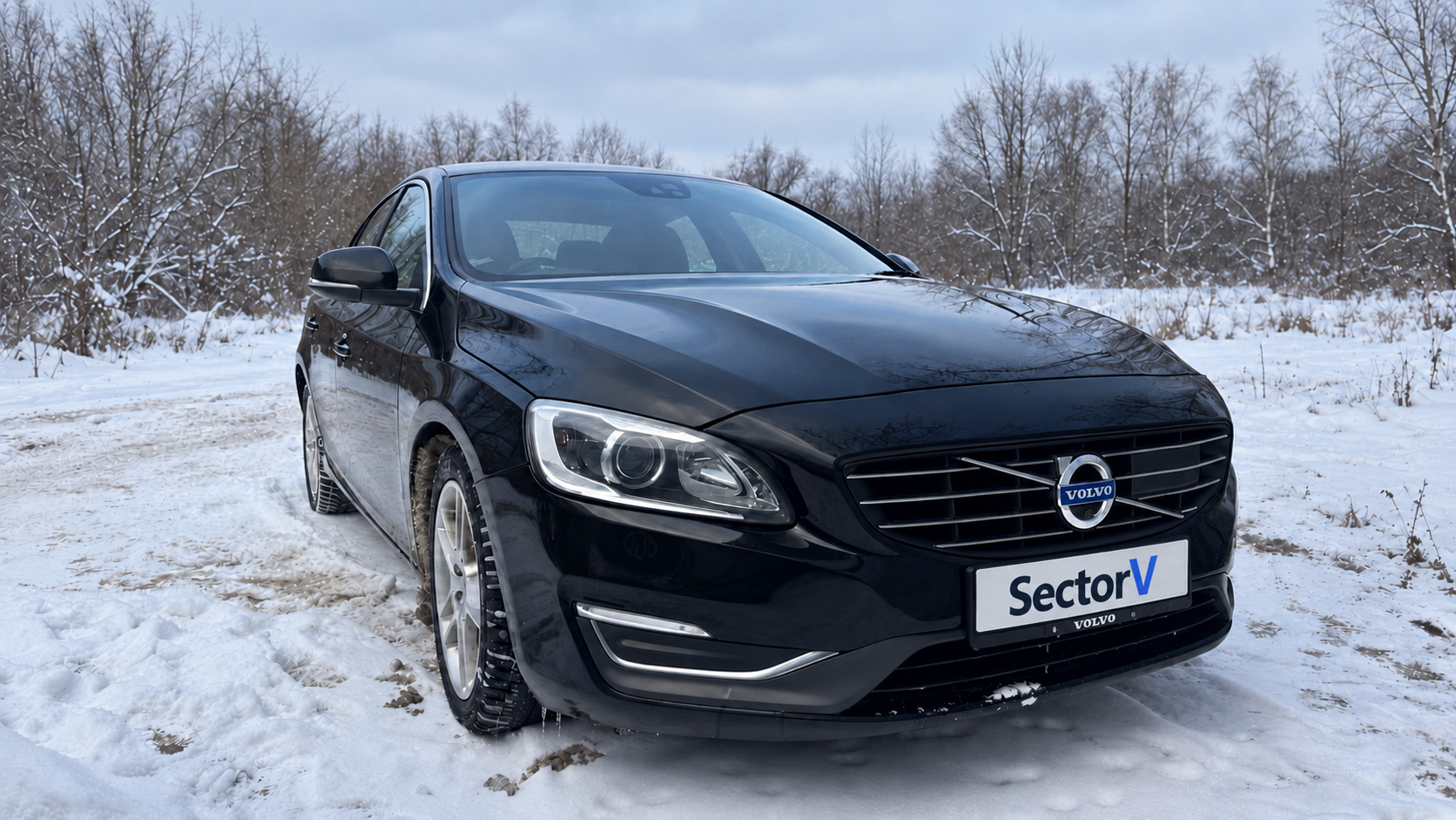 Чёрный Volvo S60 с номером SectorV на снегу